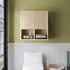 a white toilet sitting in a bathroom next to a wooden shelf filled with bottles and towels