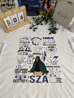 Introducing the SZA SOS Songs Shirt, a must-have for any music enthusiast! Made from premium quality cotton, this shirt is Trendy Fan Merchandise Shirt With Screen Print, Trendy Screen Print Fan Merchandise Shirt, Trendy Shirt With Fan Merchandise Screen Print, Trendy Screen Print Shirt For Fan Merchandise, Trendy Relaxed Fit Fan Merchandise Shirt, Trendy Streetwear Shirt With Front Print, Trendy Front Print Shirt For Streetwear, Trendy Cotton Shirt For Fan Merchandise, Pop Culture Cotton Shirt For Streetwear