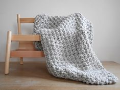 a crocheted blanket sitting on top of a wooden chair