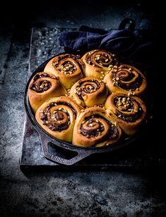 a pan filled with cinnamon rolls on top of a table