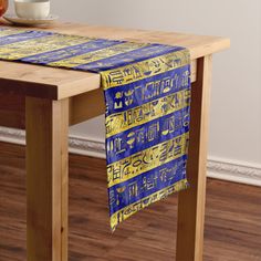 a blue and yellow table runner on a wooden table