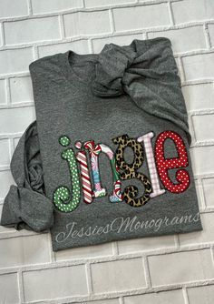 a gray shirt with the word june on it and some candy canes next to it