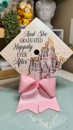 a pink graduation cap with the words and she graduated happily ever after on it sitting on top of a table