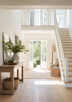 a large open floor plan with white walls and wood floors, stairs leading up to the second floor