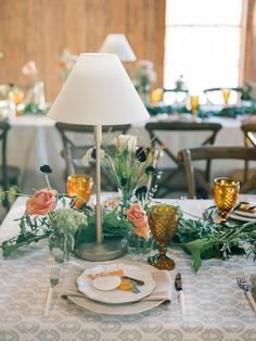 the table is set with flowers and plates