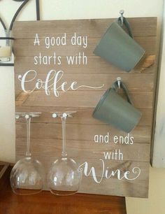 a wooden sign with three wine glasses and two cups hanging on it's side