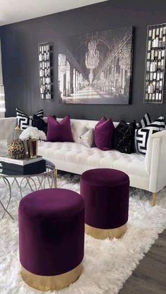 a living room filled with white furniture and lots of purple pillows on top of it