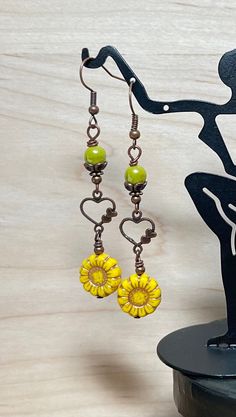 Pretty springtime boho dangle earrings.  These earrings are created using green yellow Czech sunflower beads with a copper wash, avocado green Czech beads, and antique copper heart connectors.  These earrings are great for everyday, and make a lovely gift! Total length of earrings, including the ear wire, is 2-1/2". Thank you for visiting The Lucie Collection! Handmade Bohemian Green Flower Earrings, Handmade Green Bohemian Flower Earrings, Green Heart-shaped Bohemian Earrings, Bohemian Yellow Drop Earrings, Green Bohemian Jewelry For Spring, Vintage Yellow Earrings For Summer, Yellow Bohemian Dangle Earrings, Yellow Bohemian Drop Earrings, Vintage Yellow Summer Earrings