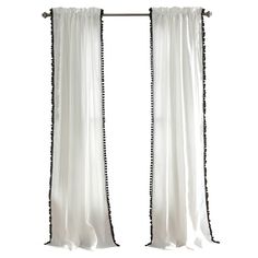 two white curtains with black beaded trims hanging from a metal rod against a white wall