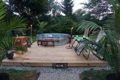 an outdoor hot tub surrounded by chairs and tables in the middle of a backyard area