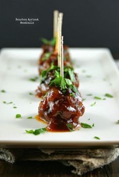 a white plate topped with meat covered in sauce and garnished with parsley