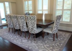 a dining room table surrounded by chairs and rug