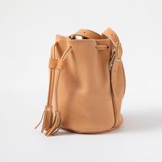 The Natural Essex Bucket Bag is an heirloom-quality bag handmade of full-grain leather. Natural Essex is a soft and squishy vegetable-tanned leather that develops a dramatic patina with wear, produced by the iconic Horween tannery in Chicago. Luxury Natural Leather Bucket Bag, Natural Leather Bag Vegetable-tanned, Bridle Leather Bags With Smooth Grain For Daily Use, Classic Leather Pouch With Soft Leather, Classic Soft Leather Pouch, Natural Leather Crossbody Bucket Bag, Leather Bucket Bag With Removable Pouch In Natural Color, Natural Soft Leather Shoulder Bag, Cognac Smooth Grain Bucket Bag