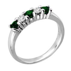 three stone ring with emeralds and diamonds on the sides, set in white gold