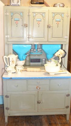 an old fashioned kitchen cabinet with two blue bowls on top