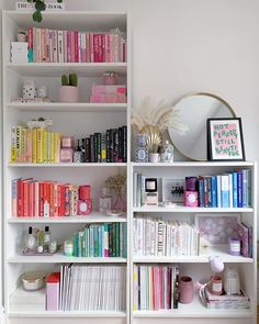 a bookshelf filled with lots of colorful books next to a wall mounted mirror