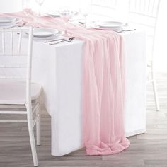 the table is set with white and pink linens