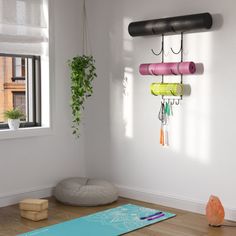 a yoga mat is sitting on the floor in front of a window with a wall hanging from it