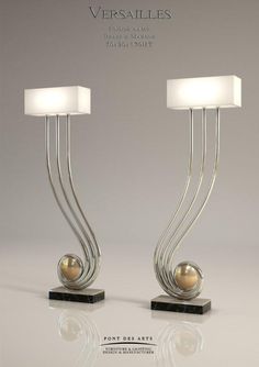 two lamps that are sitting next to each other on a table with a white light