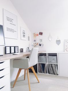 an office with white walls and shelves filled with records, cd's and cds