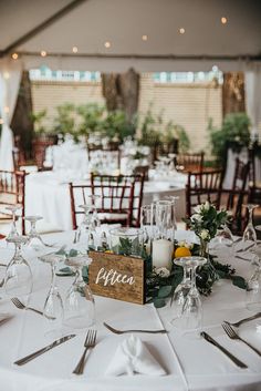 the table is set with wine glasses, silverware and candles for an elegant wedding reception