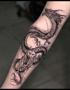 a black and white dragon tattoo on the arm