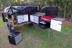 a camper trailer with its bed pulled up to it's rear end and storage compartment open