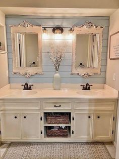 a bathroom with double sinks and two mirrors on the wall above them is decorated in white