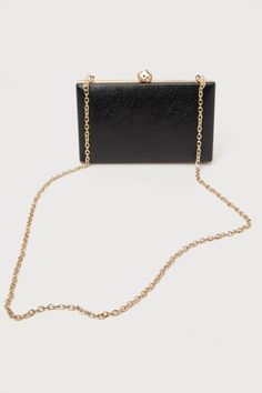 The Stylish Addition Black Snake-Embossed Clutch is the perfect finishing touch for a flawless going-out look! Snake-embossed vegan leather shapes this sleek clutch with a box silhouette and contrasting gold hardware. Undo the sculpted clasp closure to reveal a lined interior with accordion sides. Attach the removable gold chain for a chic crossbody look! Lined. Bag measures 8" wide, 5" tall, 1. 25" deep. 45"Chain strap long. Strap has a drop measurement of 23". Shell: Polyurethane. Lining: Poly Black And Gold Clutch, Black Rectangular Wallets With Chain Strap, Chic Rectangular Wallets With Gold-tone Hardware, Black Rectangular Wallet With Chain Strap, Chic Rectangular Wallet With Gold-tone Hardware, Elegant Rectangular Wallet As Fashion Accessory, Elegant Rectangular Fashion Wallet, Chic Formal Rectangular Wallet, Chic Rectangular Wallets