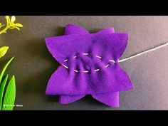 a purple flower sitting on top of a table next to flowers