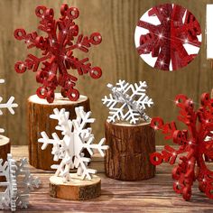 some red and white snowflakes are sitting on a wooden table next to each other