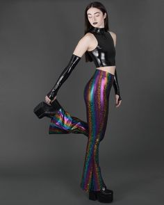 Funky sparkly holographic rainbow bell bottom leggings with high waist. These fun, futuristic, psychedelic flares are super stretchy! The perfect flared pants for any dark, disco, festival, streetwear, flow, dance wear, Burning Man, mermaidcore, glam rock, 70s, rave, hippie, robot, rocker or alt fashion colorful wardrobe! You can find the size chart in the last photo of the listing. APPROX INSEAM: XS = 33" S = 34" M = 35" L = 36"  XL = 37.5" Pictured with the Spectrum bandeau. Click here to purchase: https://www.etsy.com/listing/612357912/ This item is MADE TO ORDER. We cut and sew it after we receive your order. Fitted Rave Bottoms For Alternative Fashion, Iridescent Disco Bottoms For Party, Metallic Fitted Rave Bottoms, Iridescent Fitted Disco Bottoms, Stretch Bottoms For Halloween Party, Metallic Rave Bottoms For Party, Metallic Rave Party Bottoms, Multicolor Disco Party Bottoms, Multicolor Sequined Party Pants