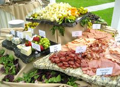 an assortment of meats and cheeses on display at a wedding or bridal event