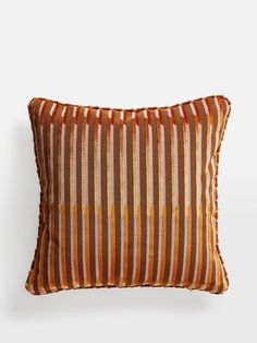 an orange and brown striped pillow on a white wall with the back side of it