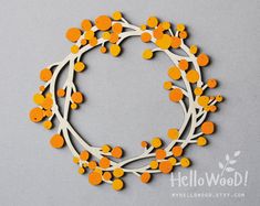 an orange and white wreath made out of buttons on a gray background with the words hello wood above it