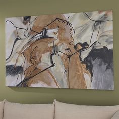 an abstract painting hangs on the wall above a couch in a living room with green walls