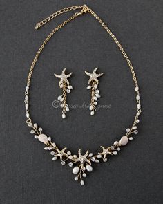 a necklace and earring set with starfishs, pearls and crystals on a gold chain