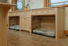 two wooden dog kennels with their doors open on the floor next to each other