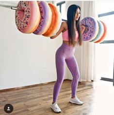 a woman in tights holding doughnuts up to her face