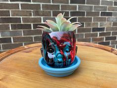 a painted potted planter sitting on top of a wooden table