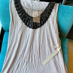 Light Grey Sleeveless Jersey Top. Long Length , Stops At Hips. Black Net And Beading Details Along Neck Line Puts A Glamorous Touch On This Tee. Beaded Sleeveless Tank Top For Spring, Spring Beaded Sleeveless Tank Top, Beaded Sleeveless Vest For Summer, Jersey Top, Long Length, Checks, Light Grey, Womens Tops, Women's Top