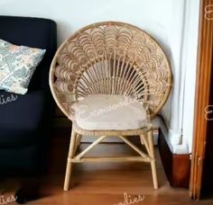 a wicker chair sitting next to a black couch in front of a white wall