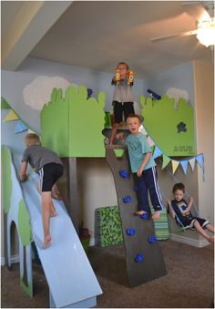 two boys are climbing up and down a slide in a bedroom with other children playing on it