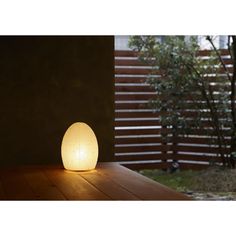 a small white light sitting on top of a wooden table