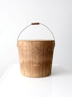 a wooden bucket sitting on top of a white table