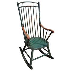 a green rocking chair with wooden handles