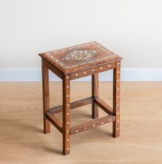 a small wooden table sitting on top of a hard wood floor