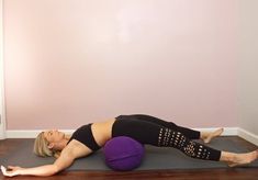 a woman laying on top of a yoga ball