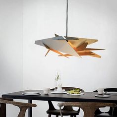 a dining room table with chairs and a light fixture hanging from the ceiling above it