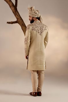 Sand Ridge Sherwani | Jatin Malik Introducing our exquisite sand grey sherwani, a true work of art in craftsmanship and style. This ensemble is intricately hand-embroidered with resham, silver threads, dabka, and zari, creating a mesmerizing tapestry of textures and designs. Each stitch reflects meticulous attention to detail, showcasing the mastery of traditional techniques. Perfect for those who appreciate sophistication and elegance, this sherwani is sure to command attention and leave a lasting impression at any special occasion or event. Included in purchase: Sherwani, Kurta, Churidar, Safa Product Specification Color: Sand grey Fabric: Linen silk Occasion: Engagement, Wedding, Bridal, Reception Style: Sherwani, Kurta, Churidar, Safa Care: Dry Clean Work: Hand Embroidery Customization Grey Sherwani, Jatin Malik, Blouse Yoke, Sherwani Groom, Dhoti Pants, Haldi Ceremony, Indian Man, Color Sand, Indian Wedding Outfits